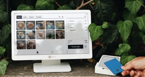 A person holding a blue card in front of a computer