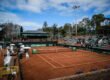 a tennis court with a crowd of people watching it