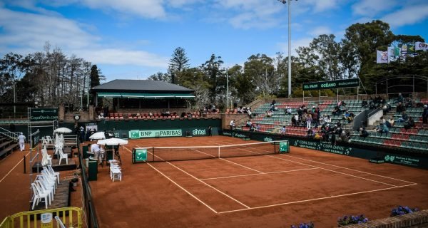 a tennis court with a crowd of people watching it