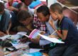 boy in blue and white plaid shirt reading book