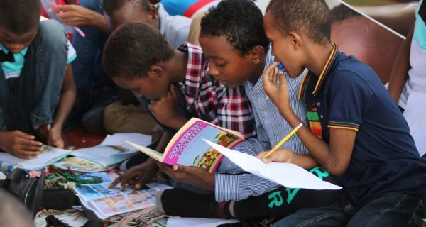 boy in blue and white plaid shirt reading book