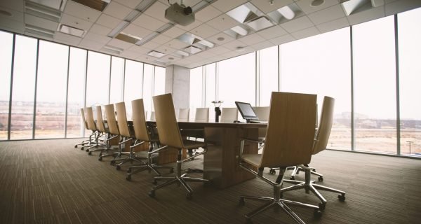 oval brown wooden conference table and chairs inside conference room