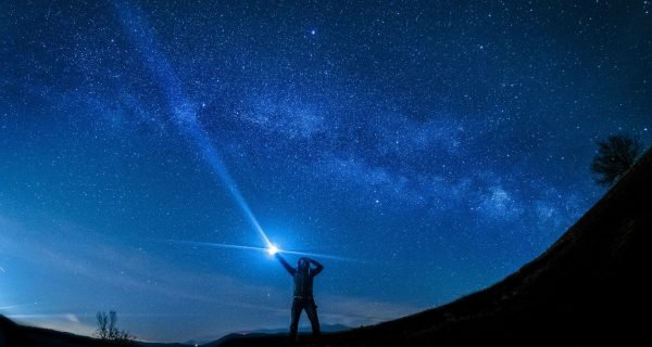 silhouette of man holding flashlight