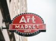 a red sign hanging from the side of a building