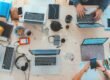 people sitting down near table with assorted laptop computers