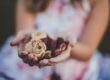 selective focus photography of a girl holding flowers