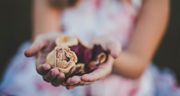 selective focus photography of a girl holding flowers