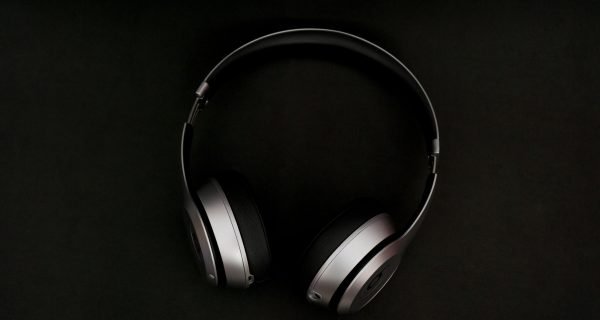 silver headphones on top of black surface