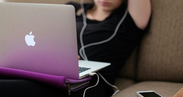 woman sitting on sofa with MacBook Air