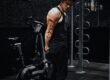 man in black tank top and black pants standing on black exercise equipment