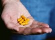 yellow medication pill on persons hand